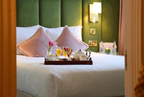 a bed with a tray with drinks and flowers on it at Kilronan House in Dublin