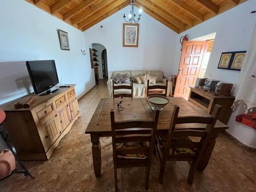 sala de estar con mesa de madera y TV en Casa Rural Quilla, en Agulo
