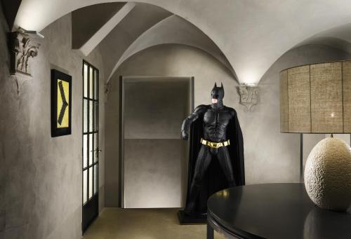 a batman statue in a hallway with a table at Hotel Garibaldi Blu - WTB Hotels in Florence