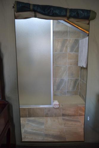 a shower with a glass door in a bathroom at The Farmers Lodge in Thorndale