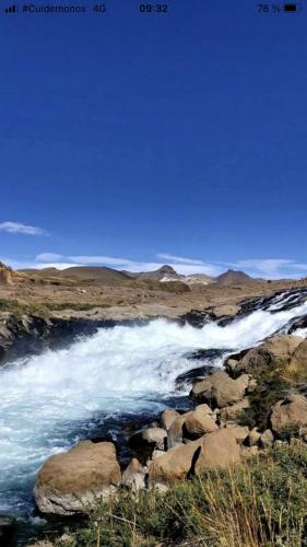 a stream of water with rocks in a field at Cabaña En Lago colbun, sector Pasó Nevado in Talca