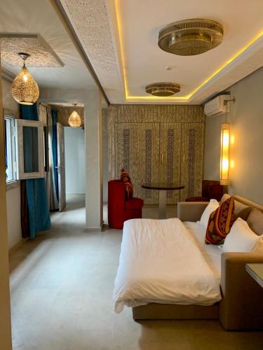 a bedroom with a bed and a couch and a table at Villa Margaux in Essaouira