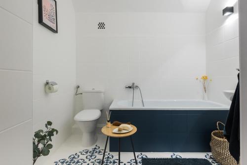 een badkamer met een bad, een toilet en een tafel bij Pöttyös Ponty Elegance Boutique Vendégház in Kisköre