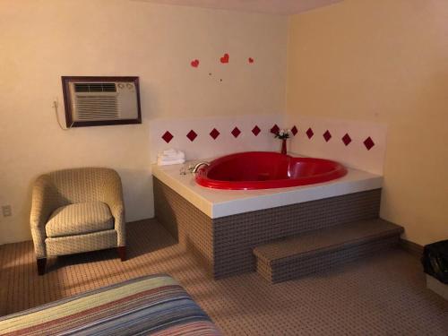 La salle de bains est pourvue d'une baignoire rouge et d'une chaise. dans l'établissement Motel Boutique by Wolf Inn, à Milan