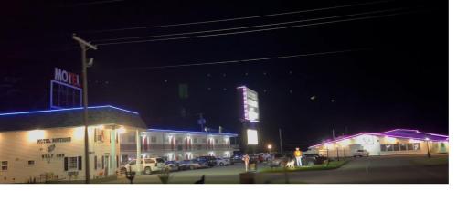 a group of people standing outside a building at night at Motel Boutique by Wolf Inn in Milan