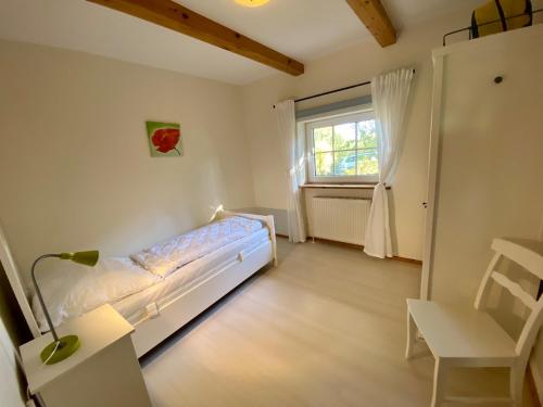 ein kleines Schlafzimmer mit einem Bett und einem Fenster in der Unterkunft 1000 - Lüntsches Schloss Riepsdorf in Thomsdorf