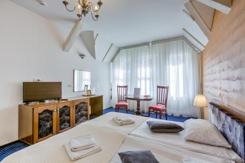 1 dormitorio con 1 cama, mesa y sillas en Residence Central Annapolis en Brasov
