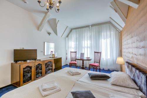 um quarto com uma cama, uma mesa e cadeiras em Residence Central Annapolis em Brasov