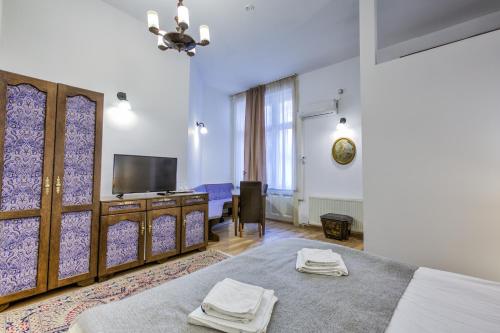 a hotel room with a bed and a tv at Residence Central Annapolis in Braşov