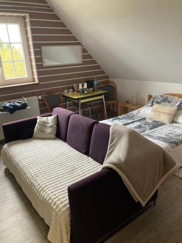 a bedroom with a bed with a purple couch at La Marokanette in Saint-Maclou-de-Folleville