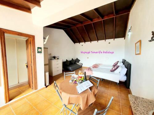 een woonkamer met een tafel en een bed bij Rinconcito Rural con encanto en Las Hayas in Acardece