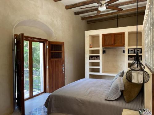 a bedroom with a bed and a ceiling fan at Destino Mío Mayan Jungle Retreat in Tekit