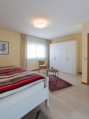 a bedroom with a bed and a chair and a table at Ferienwohnung Lohrig in Weiskirchen