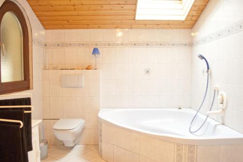 a white bathroom with a tub and a toilet at Apartment Hufnagl in Altmünster