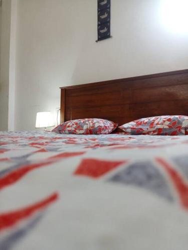 uma cama com um cobertor e almofadas vermelhos e brancos em Relaxing apartment l Revenla garden l em Matara
