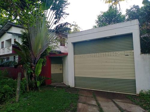 uma grande porta de garagem ao lado de uma casa em Relaxing apartment l Revenla garden l em Matara