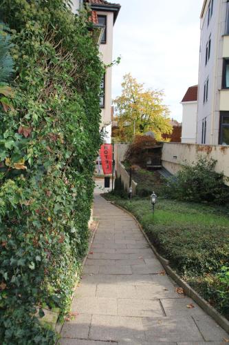 a sidewalk next to a ivy covered building at Hotel Rosengarten in Bad Salzuflen