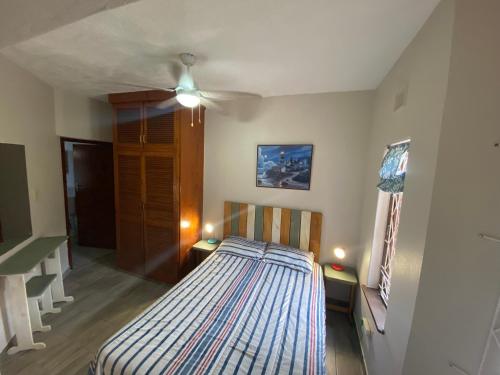 a bedroom with a bed and a ceiling fan at See Uitsig 2 in Uvongo Beach