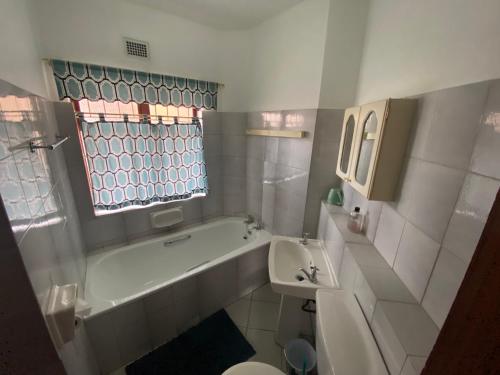 a bathroom with a tub and a toilet and a sink at See Uitsig 2 in Uvongo Beach