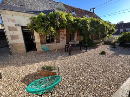 a house with a gravel yard with a table and chairs at La Maison de Frédéric in Francueil