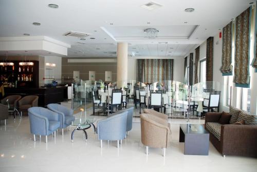 a restaurant with blue chairs and tables in a room at Letsos Hotel in Alykes