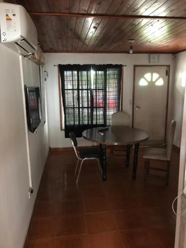 Habitación con mesa, silla y puerta en rancho de los bellidos en Perico