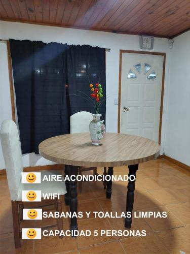 Una mesa en una habitación con un jarrón de flores. en rancho de los bellidos en Perico