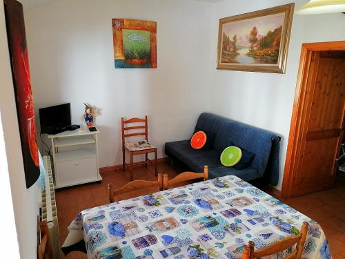 a living room with a blue couch and a table at Appartamento La Foresta Abetone in Abetone