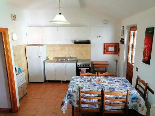 eine kleine Küche mit einem Tisch, einem Tisch und Stühlen in der Unterkunft Appartamento La Foresta Abetone in Abetone