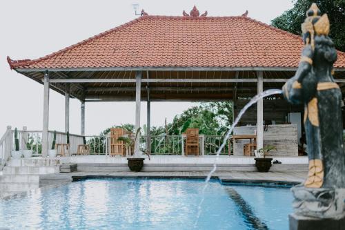 a pool with a gazebo and a fountain at Lanussa Hill Villa in Nusa Lembongan