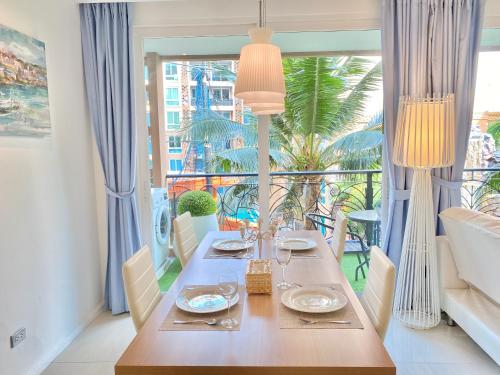 a dining room with a table and a large window at Atlantis Condo & Resort by Luxury Collection Apartment in Jomtien Beach