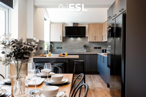 a kitchen with a table with chairs and a refrigerator at Central 5 Bedroom Townhouse perfectly located 2 mins walk from the Train Station in Chester