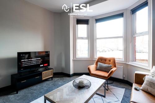 a living room with a couch and a tv at Central 5 Bedroom Townhouse perfectly located 2 mins walk from the Train Station in Chester