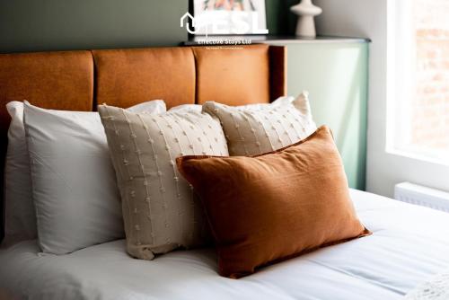 a bunch of pillows sitting on a bed at Central 5 Bedroom Townhouse perfectly located 2 mins walk from the Train Station in Chester