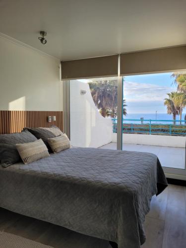 a bedroom with a bed and a view of the ocean at Playa Paraíso Resort in Concón