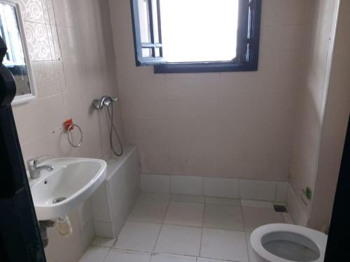 a bathroom with a sink and a toilet and a window at sultana duplex 3 pour les familles in Oualidia