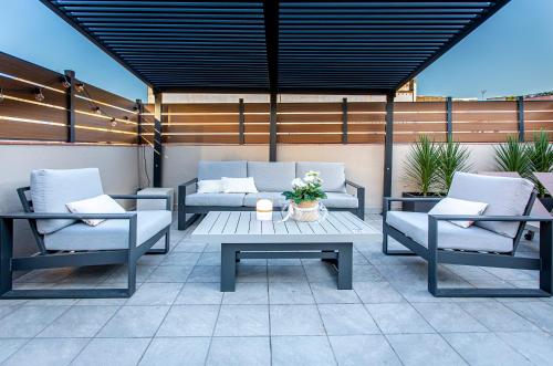 a patio with two chairs and a table and a couch at Barcelona Touch Apartments in Hospitalet de Llobregat