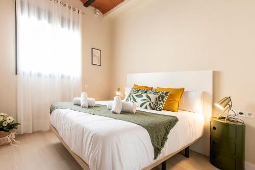 a bedroom with a large white bed with a window at Barcelona Touch Apartments in Hospitalet de Llobregat