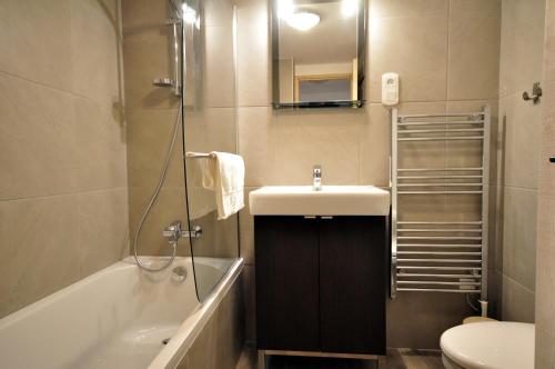 La salle de bains est pourvue d'un lavabo, d'une baignoire et de toilettes. dans l'établissement Près des Forts, à Briançon