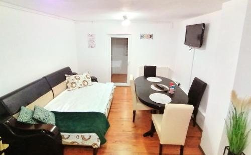 Una pequeña sala de estar con una mesa y un sofá. en Apartament Cetate, en Alba Iulia