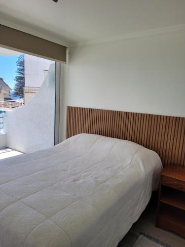 1 dormitorio con cama blanca y ventana grande en Playa Paraíso Resort, en Concón