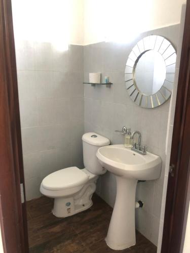 a bathroom with a toilet and a sink and a mirror at Ananta Hotel in Las Casitas