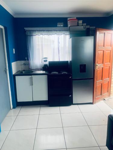 a kitchen with a refrigerator and a sink at Orange Grove in Mthatha