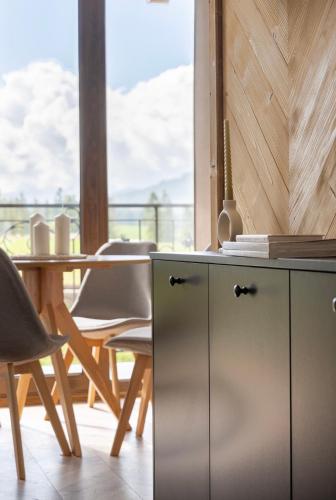 a kitchen with a table and chairs and a cabinet at Jedla Apartments in Dzianisz