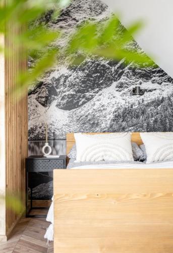 a bedroom with a bed with a black and white wall at Jedla Apartments in Dzianisz