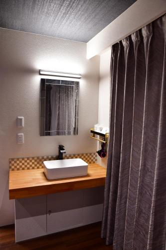 a bathroom with a sink and a mirror at Villa 33 Kashikojima in Ugata