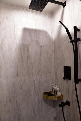 a bathroom with a shower and a wall with a sink at Villa 33 Kashikojima in Ugata
