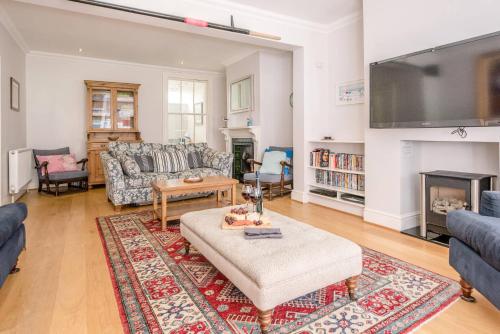 a living room with a couch and a tv at The Pink House in Southwold in Southwold