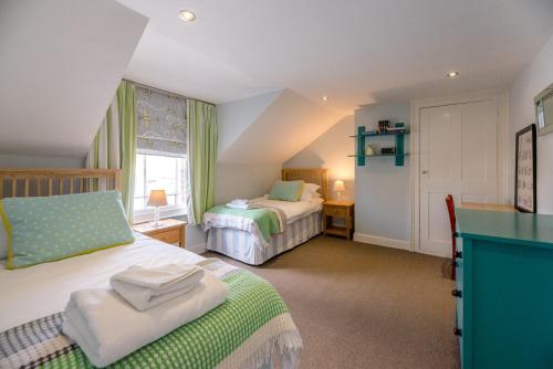 a bedroom with two beds and a desk in it at The Pink House in Southwold in Southwold