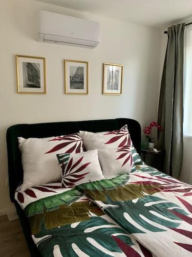 1 cama con sábanas y almohadas coloridas en un dormitorio en Sicomoro Casa en Sopron